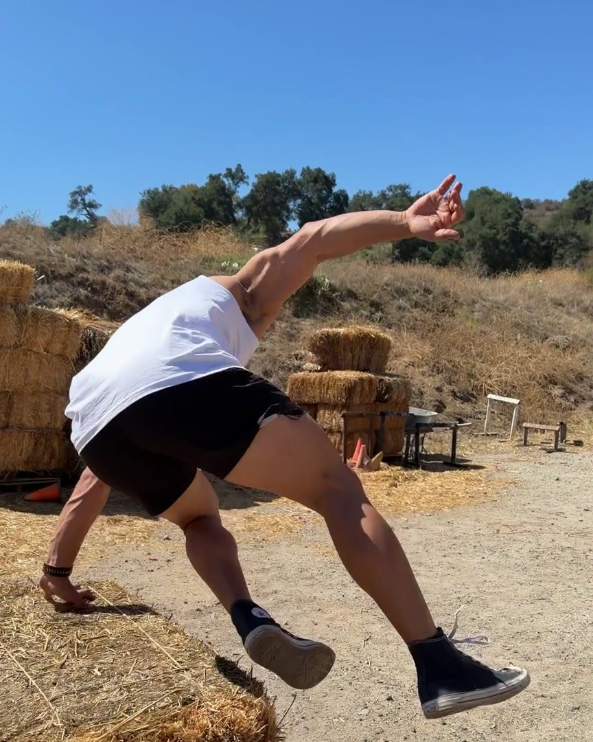 Athlete vaulting a hay bale at speed in All Corners shorts