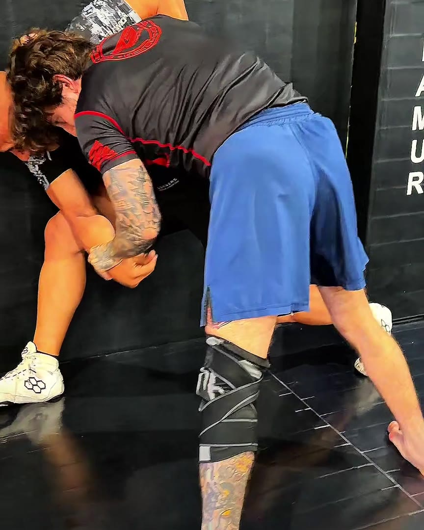 Two grapplers working a takedown on the mat