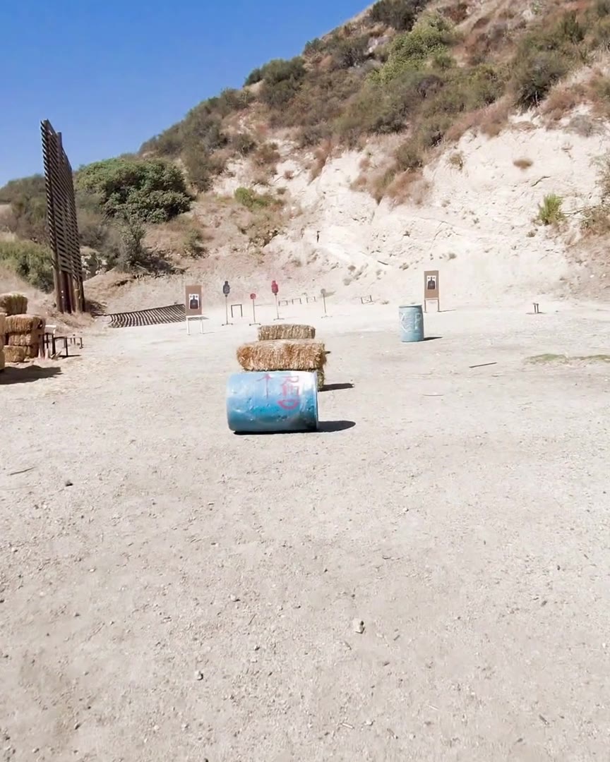An outdoor shooting range with hay bales and steel targets